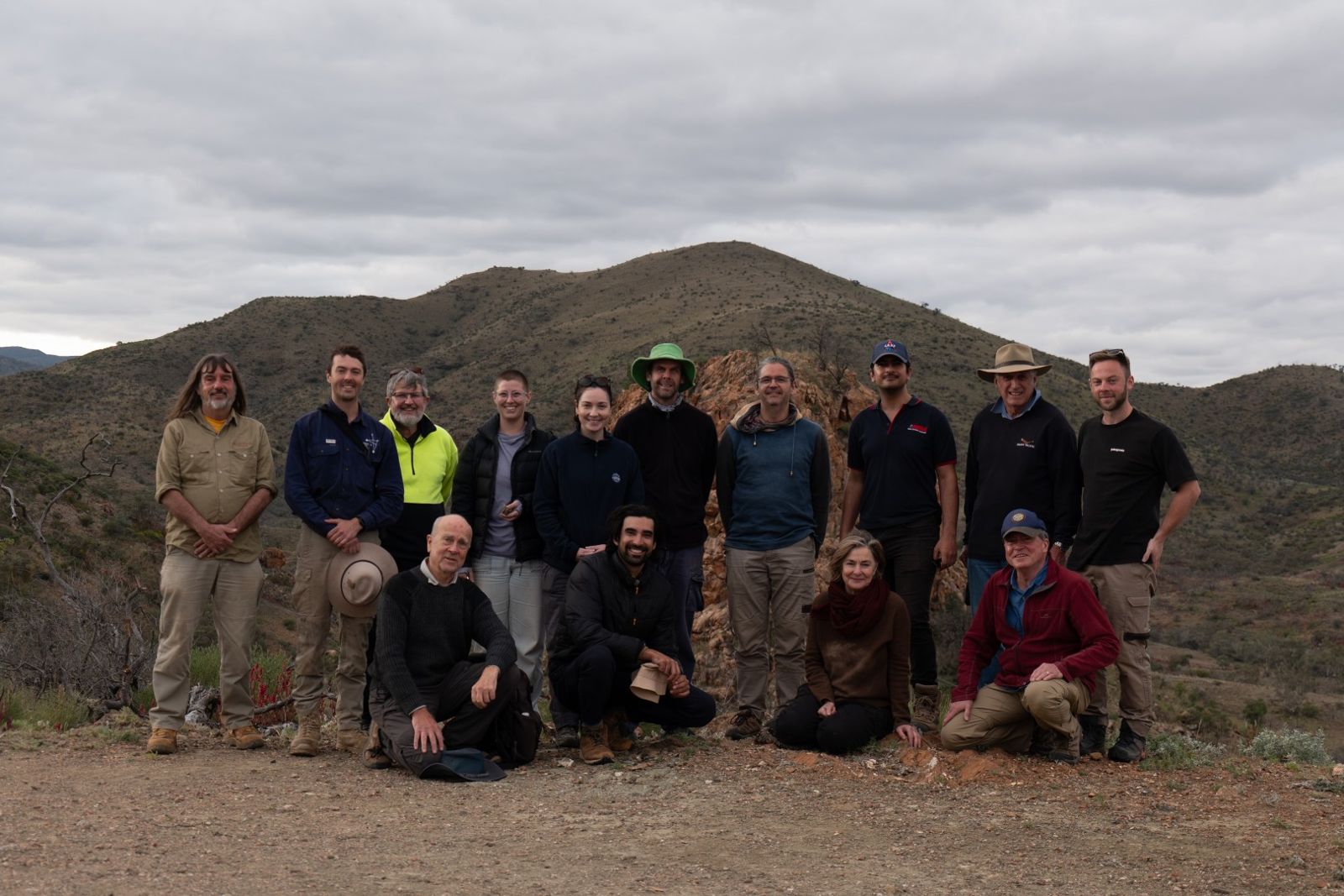 The Rock Wallaby 1 team posing for a group photo in front of hills